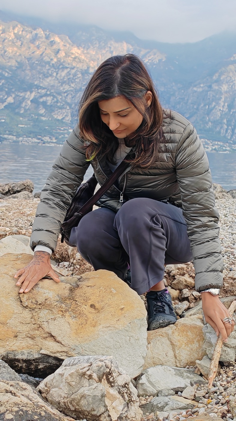 Pallavi crouched at the lake edge, hands on the stone