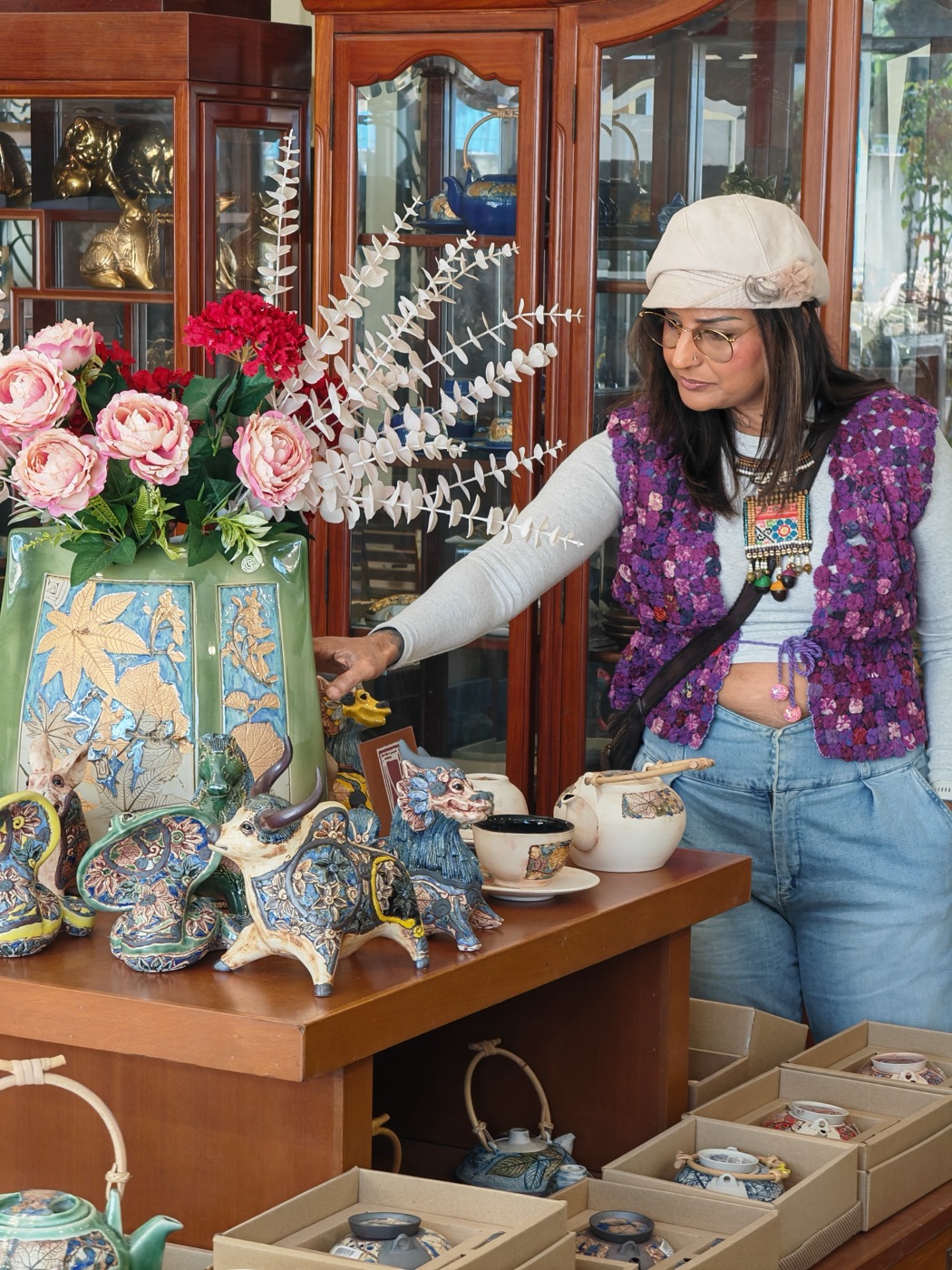 Pallavi among painted vases in the ceramic factory shop