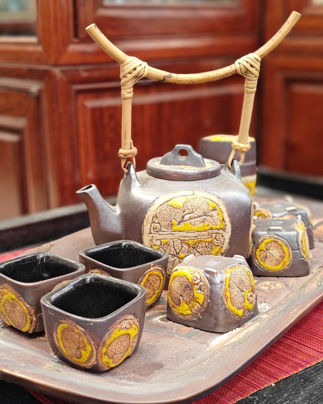A stoneware tea set with cane handles
