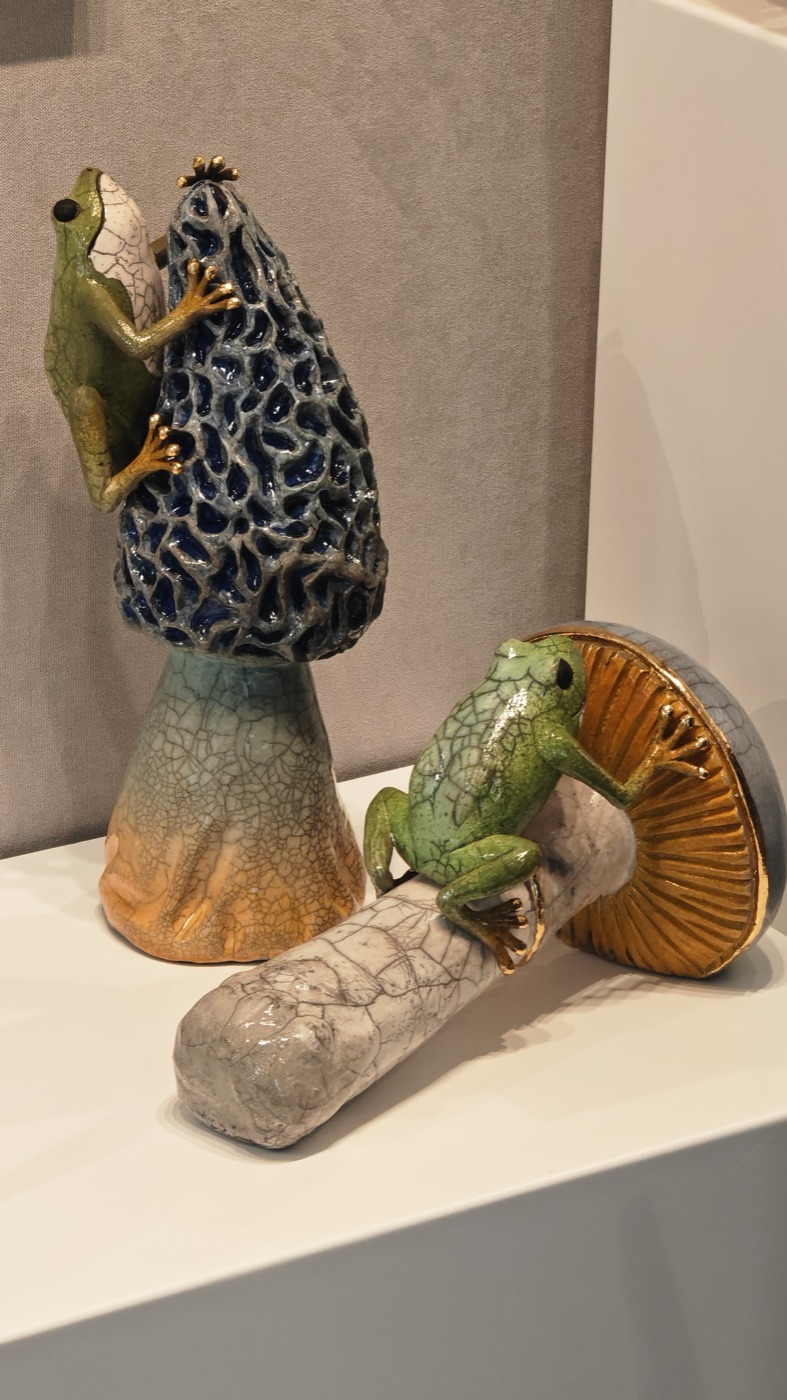 Ceramic frogs resting on glazed mushroom sculptures