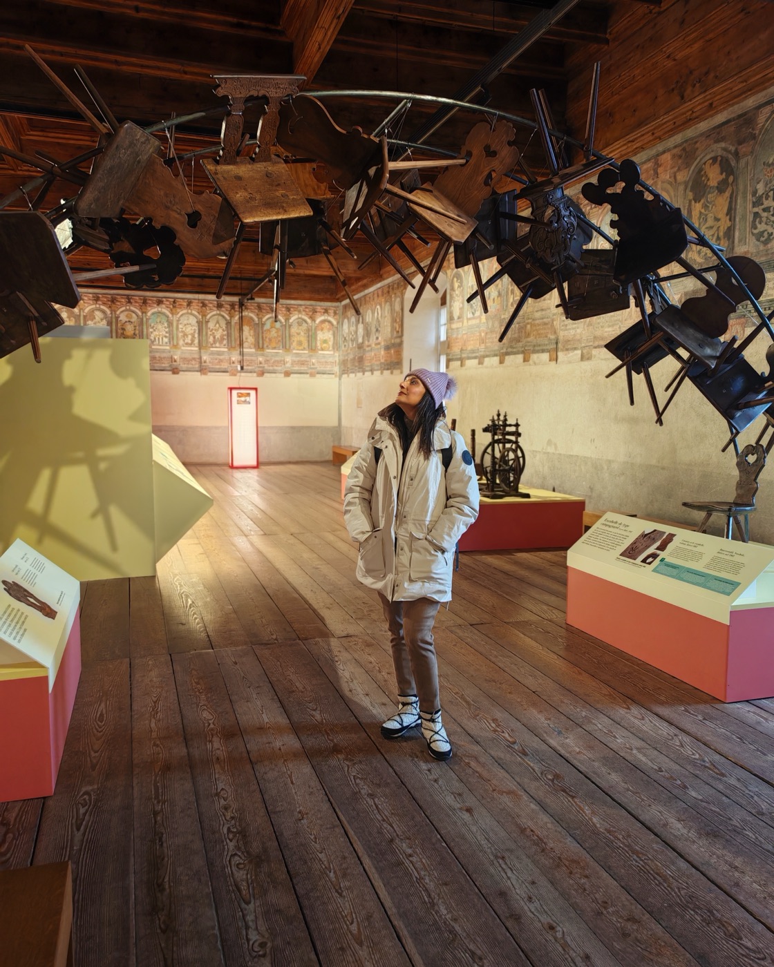 Pallavi looking up at an installation of suspended chairs